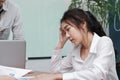 Depressed exhausted young Asian business woman suffering from severe depression between meeting in office. Royalty Free Stock Photo