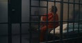 Depressed female prisoner sits on bed in prison cell Royalty Free Stock Photo