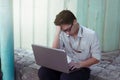 Depressed frustrated young Asian business man using laptop looking serious