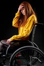 depressed hopeless redhead female sits on wheelchair unhappy