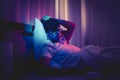 Depressed insomnia man holding his head on a bed late at night with Black Medical pills for stress and suicide concept Royalty Free Stock Photo