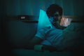 Depressed insomnia white man holding on a bed late at night with Black Medical pills for stress and suicide concept Royalty Free Stock Photo