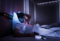 Depressed insomnia white man holding head on a bed late at night with Black Medical pills for stress and suicide concept Royalty Free Stock Photo