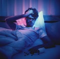 Depressed insomnia man holding his head on a bed late at night with Black Medical pills for stress and suicide concept Royalty Free Stock Photo