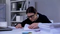 Depressed lady in suit looking through pile of documents, overload of work