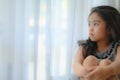 Depressed Little girl near window at home, closeup Royalty Free Stock Photo