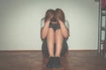 Depressed and lonely girl abused as young sitting alone in her room on the floor feeling miserable and anxiety cry over her life, Royalty Free Stock Photo