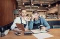 Restaurant young business owners checking papers after closing hours. Royalty Free Stock Photo