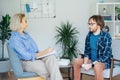 Depressed male patient having psychotherapy session with counselor at mental health clinic. Man with emotional problems Royalty Free Stock Photo