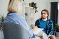 Depressed male patient having psychotherapy session with counselor at mental health clinic. Man with emotional problems Royalty Free Stock Photo