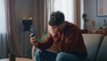 Depressed man looking cellphone web camera on couch. Sad guy feeling stress Royalty Free Stock Photo