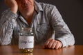 Depressed Man Looking At Empty Jar Labelled College Fund Royalty Free Stock Photo