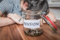 Depressed man lying on table. Pension savings in jar in front Royalty Free Stock Photo