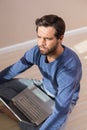 Depressed man sitting on floor using laptop Royalty Free Stock Photo