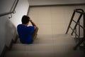 Depressed man sitting on stair of residence building. Sad man, Cry, drama, lonely and unhappy concept Royalty Free Stock Photo