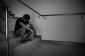 Depressed man sitting on stair of residence building. Sad man, Cry, drama, lonely and unhappy concept Royalty Free Stock Photo