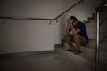 Depressed man sitting on stair of residence building. Sad man, Cry, drama, lonely and unhappy concept