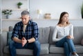 Depressed mature man and woman having relationship problems, going through marital crisis at home Royalty Free Stock Photo