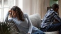 Stressed black couple sit separately thinking of breakup