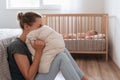 Depressed mother screaming with desperation in pillow to overcome negative emotions