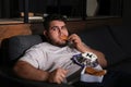 Depressed overweight man eating sweets in room at night Royalty Free Stock Photo