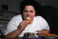 Depressed overweight woman eating sweets in kitchen Royalty Free Stock Photo