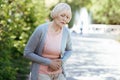 Depressed pensioner having stomachache outdoors Royalty Free Stock Photo