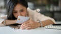 Depressed and sad Asian woman laid her head down on the table, having financial problems Royalty Free Stock Photo