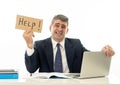 Depressed sad and frustrated middle aged businessman holding a help sign