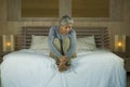 Depressed and sad grey hair mature woman crying lonely sitting on bed suffering crisis in pain and depression problem feeling lost Royalty Free Stock Photo