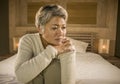 Depressed and sad grey hair mature woman crying lonely sitting on bed suffering crisis in pain and depression problem feeling lost Royalty Free Stock Photo