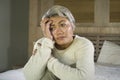 Depressed and sad grey hair mature woman crying lonely sitting on bed suffering crisis in pain and depression problem feeling lost Royalty Free Stock Photo