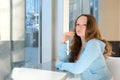 Depressed, sad woman at home looking out window for mental health, depression or heartbreak. Young gen z girl alone in Royalty Free Stock Photo