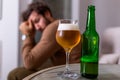 Depressed sad young addicted man feeling bad drinking beer alone at home, stressed frustrated lonely drinker alcoholic suffer from Royalty Free Stock Photo