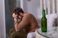 Depressed sad young addicted man feeling bad drinking beer alone at home, stressed frustrated lonely drinker alcoholic suffer from Royalty Free Stock Photo