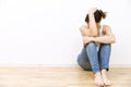 Depressed, sad, young woman sitting on floor holding her head Royalty Free Stock Photo