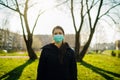 Depressed scared person wearing a mask to prevent contracting disease in spring nature.Coronavirus pandemic life.Panic and fear of Royalty Free Stock Photo