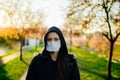 Depressed scared person wearing a N95 mask to prevent contracting disease in spring nature.Coronavirus pandemic life.Infection Royalty Free Stock Photo