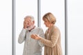 Depressed senior man. Elderly man suffering from headache and takes care by his wife Royalty Free Stock Photo