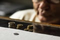 Depressed senior man in glasses sitting at the table and counting coins in a period of crisis. Pensioner poverty concept Royalty Free Stock Photo