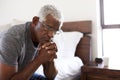 Depressed Senior Man Looking Unhappy Sitting On Side Of Bed At Home With Head In Hands Royalty Free Stock Photo