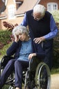 Depressed Senior Woman In Wheelchair Being Pushed By Husband Royalty Free Stock Photo