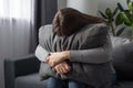 Depressed single young woman holding pillow going through emotional crisis after abuse abortion sitting on couch at alone home. Royalty Free Stock Photo