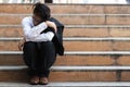 Depressed stressed young Asian business man in suit suffering from severe depression sitting on stairs. Unemployment and layoff Royalty Free Stock Photo