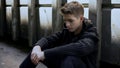 Depressed teen feeling lonely, sitting in abandoned house, no support and care Royalty Free Stock Photo