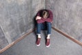 Depressed teenage boy sitting on floor