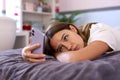 Depressed Teenage Girl Lying On Bed At Home Looking At Mobile Phone Royalty Free Stock Photo