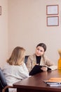 Depressed teenage girl with therapist. Teen crying during psychologist counseling about Bullying in school Royalty Free Stock Photo