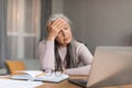 Depressed tired european mature woman with gray hair suffers from headache, got stress and unhappy face Royalty Free Stock Photo