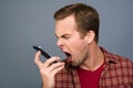 Depressed tired young man screaming on his mobile phone Royalty Free Stock Photo